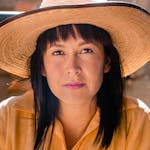 Close-up portrait of a Hispanic woman wearing a straw hat outdoors in Mexico.