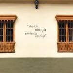 Colorful house facade in Bogotá with an inspiring Spanish quote on the wall, perfect for travel themes.